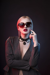 Glamorous blonde lady in glasses with bright makeup