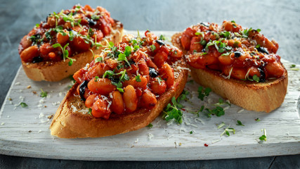 Beans fried in tomato sauce on toasted bread with cross salad sprinkle