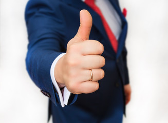 Man in suit shows his hand a sign of super