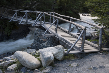 Pedestrian wooden bridge over a mountain stream. National Park Torres del Paine. Chile.