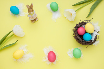 Fototapeta na wymiar Easter yellow frame with bunny, eggs, tulips. Top view