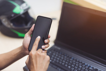 Senior design engineer using cell phone while working about engineering in selective focus. motorcycle helmet, calculator, laptop, monitor on working desk..man hard working.