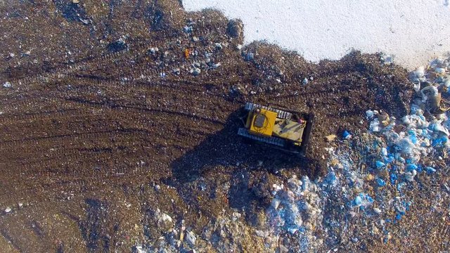 Special machinery working at the garbage dump. Landfill directly from above. Aerial shot. 4K.