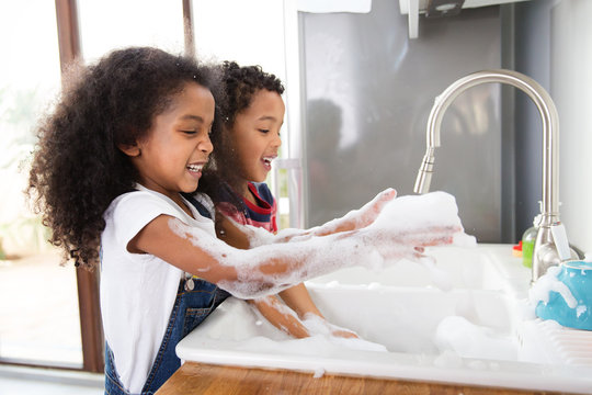 Un gar&ccedil;on et une fille font la vaisselle dans la cuisine