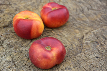 fresh organic flat nectarines on an old rustic background