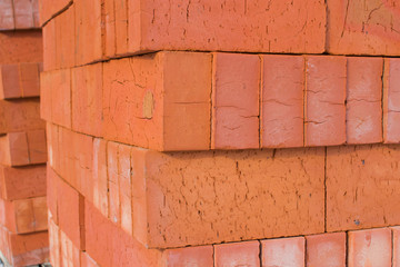 A pile of construction bricks orange color at the construction site closeup