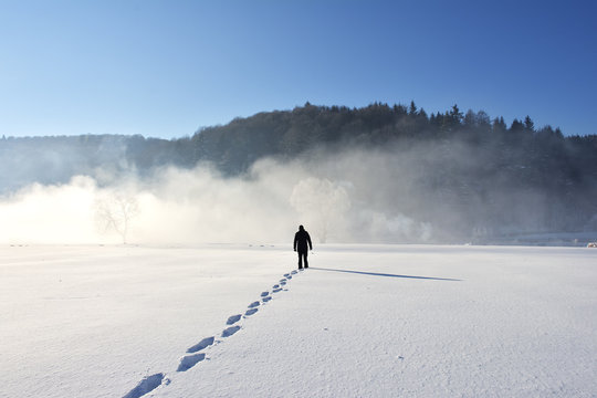 Man walking on snow, footprints in snow, behind