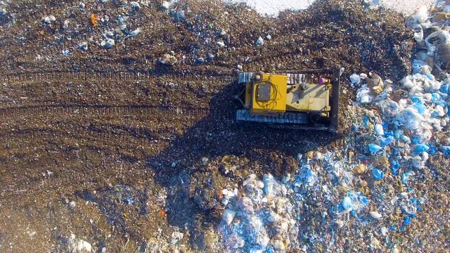 Special machinery working at the garbage dump. Landfill directly from above. Aerial shot. 4K.