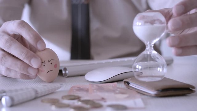 Businessman rotating hourglass.Businessman beats per mouse with Easter egg