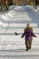 Child in lilac winter clothes running in snow winter park