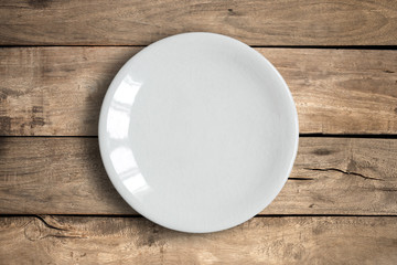 Top view of blank dish on a wood background.