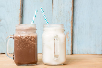 Milkshake put on wooden in blue wall room. Pastel tone.