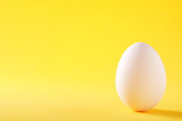 Naklejka na ściany i meble white egg on a yellow background