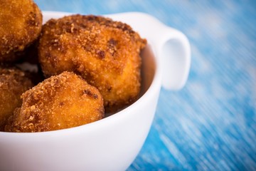 Detail of several pieces of fried cauliflower on blue board