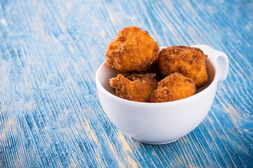 Few pieces of fried cauliflower in white cup