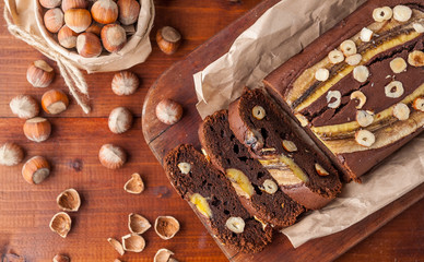 Chocolate cake with banana and hazelnut on a wooden background