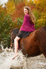 Hübsches Mädchen mit Pferd im See