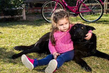 Young girl with dog playing in garden