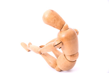 Depressed and sad wooden doll on a white background. Bad emotions concept.