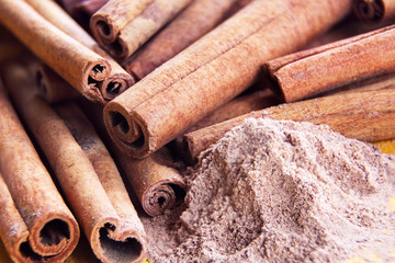 heap of cinnamon sticks and cinnamon powder 