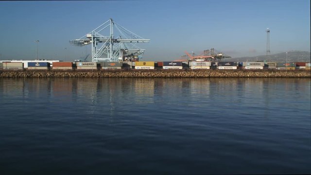 Flight from water level passing over loading cranes and container ships in Los Angeles Harbor. Shot in 2010.