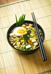 Miso soup in black bowl, ready to eat