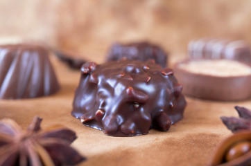 Some chocolate candies with brownie taste on the brown background. Selective focus.