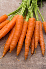 Fresh and sweet carrot on a grey wooden table.