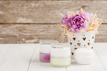 Fototapeta na wymiar Beauty products, cosmetics, lit candle and purple tulips