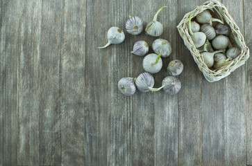 Obraz na płótnie Canvas Garlic in the basket on wooden table