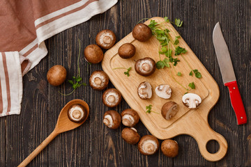 Italian style dinner. Mushroom on wooden boards with fresh basil leaves over old rustic background. Top view, vertical composition.