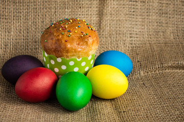 Colored Easter eggs and a festive cake on a rustic background