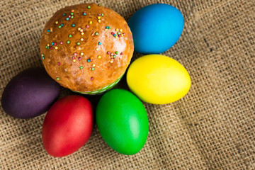 Colored Easter eggs and a festive cake on a rustic background