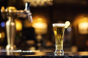Beer, a glass of fresh cold beer on the bar.A pub.Bar.Restaurant.Classic.Evening.European restaurant.European bar.American restaurant.American bar.strong drink