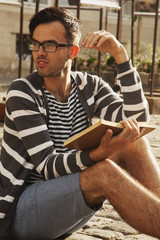 Young man relaxing and reading a book.