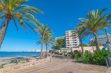 Ibiza sunshine on the waterfront in Sant Antoni de Portmany,  Take a walk along the main boardwalk, now a stone concourse beside the beach.  Places to stay in Ibiza. 