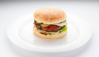 Big burger on a white plate isolated on white background.