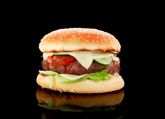 Big burger over black background.