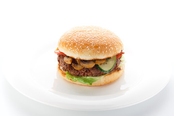 Big burger on a white plate isolated on white background.