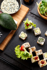 Fototapeta na wymiar Vegetarian sushi roll on a stone plate and dark concrete background