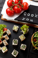 Vegetarian sushi roll on a stone plate and dark concrete background