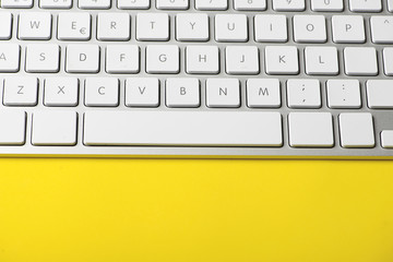 White keyboard of a computer on yellow background. Technology. Vertical shoot.