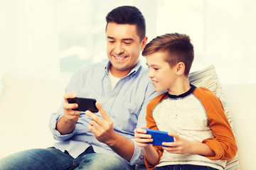 happy father and son with smartphones at home
