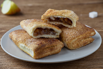 Delicious puff pastry with apples on a wooden background