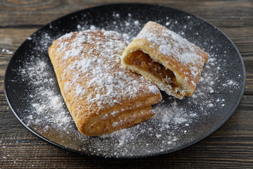 Delicious puff pastry with apples on a wooden background