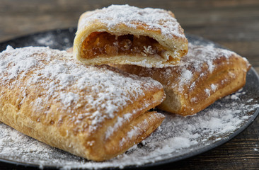 Delicious puff pastry with apples on a wooden background