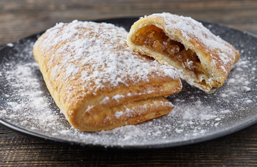 Delicious puff pastry with apples on a wooden background