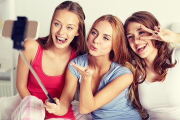 teen girls with smartphone taking selfie at home