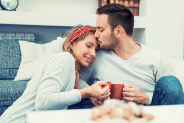 Couple relax at home with cup of coffee