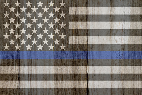 A rustic old thin blue line flag on weathered wood